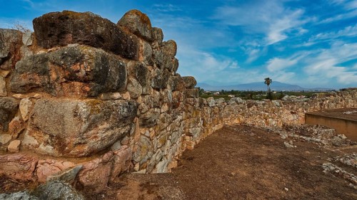 Sky replaced, cyclopean wall, massive stone wall structure in a ruined landscape under a clear sky,