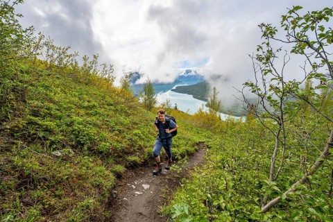 Climbers on a hiking trail, Slaughter Ridge Trail, view of snowy mountains and turquoise lake Kenai