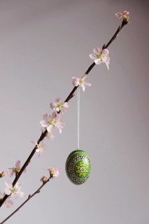 Blooming branches of a peach tree in a vase decorated with Easter egg, spring, Germany