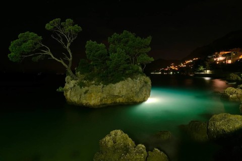 Rock island with illumintaion at night in Brela, Croatia