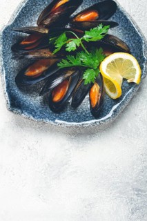 Mussels in shells, boiled in their own juice, in a bowl, gray background, top view, homemade, no