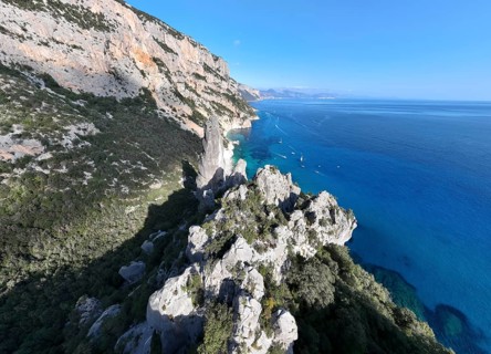 Picturesque rocky coast, cliffs with L'Aguglia pinnacle, blue sea and Cala Goloritzé beach, aerial