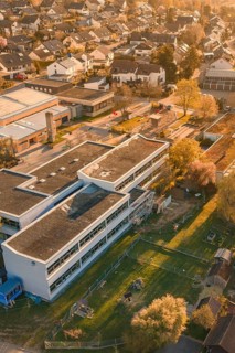 School complex and residential buildings surrounded by autumn gardens and trees, Schlehengäuschule,