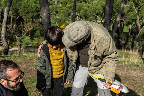 Three generations come together in an urban park or forest, participating in eco-friendly
