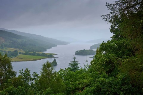 Calm lake under cloudy sky surrounded by green hills and thick vegetation, Queens View, Fincastle,