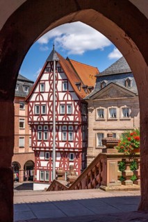 View through an archway of the Abbey Basilica of the reconstructed half-timbered building of the