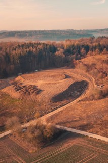 Large hill surrounded by fields and trees, aerial view in soft morning light, landfill, Gechingen,