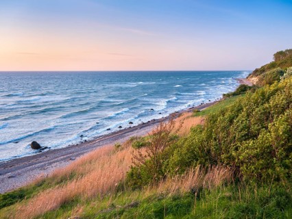 Unspoiled secluded stretch of coast with cliffs in the evening light, view of the beach with