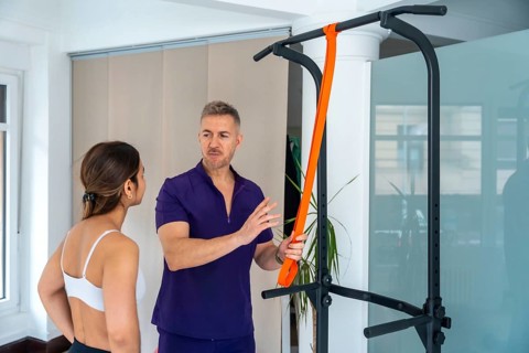 Physiotherapist consulting a young woman about medical recovery and rehabilitation exercise,