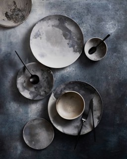 Top view of a sophisticated arrangement of ceramic tableware featuring plates and bowls with a