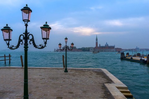 View of the island of San Giorgio Maggiore, with historic three-armed lanterns in front, Venice,
