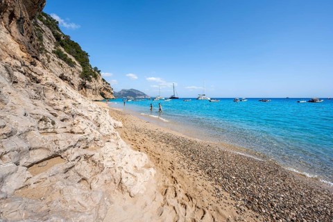 Sandy beach beach and steep cliffs at Cala Luna, Golfo di Orosei, Baunei, Sardinia, Italy