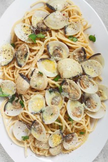 Spaghetti with vongole clams, in cream sauce, carbonara, on a white plate, homemade, top view, no