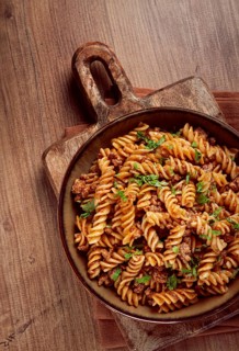 Pasta in the navy, pasta with minced meat, plate on a wooden table, homemade, fusilli pasta,