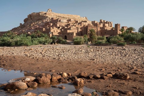 A stunning view of an ancient Moroccan kasbah, nestled in the rocky desert terrain Ksar of Ait Ben