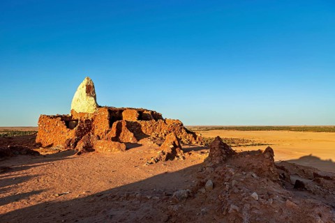 Ancient ruins in a vast desert landscape under a clear blue sky, An old cemetery in the Sahara in