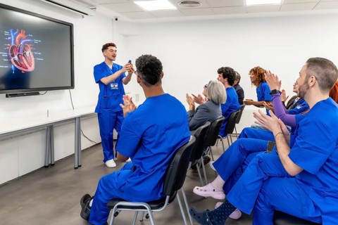 Medical student delivering a presentation about human heart anatomy to a diverse group of
