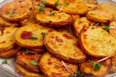 Crispy potato slices, with parmesan cheese and spices, fried in the oven, homemade, no people