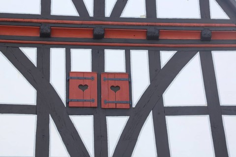 Heart-shaped decoration of shutters with two hearts, half-timbered house, brown wooden beams,