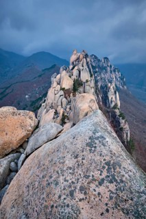 View of stones and rock formations from Ulsanbawi rock peak in stormy weather with clouds.