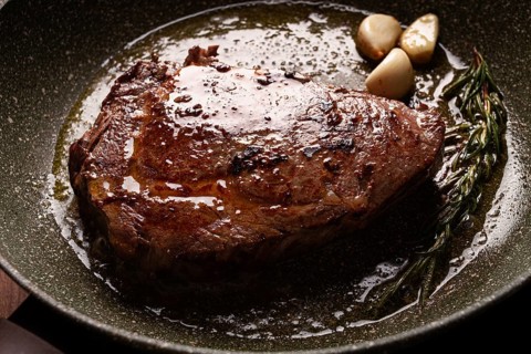 Fried steak, beef steak, rib eye steak, in a frying pan, top view, no people