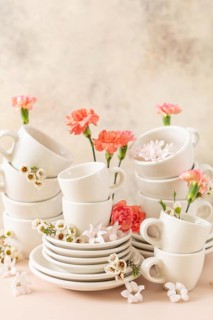 Set of white cups, plates, and saucers beautifully decorated with fresh pink and white spring
