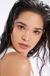 Studio portrait of a young female model with wet hair and salt crystals on her face and shoulder,
