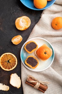 Truffle chocolate tangerine candies on a black concrete background and linen textile. top view,