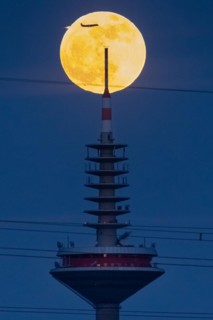 The full moon passes behind the top of the Europaturm in Frankfurt am Main, Frankfurt am Main,