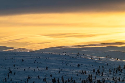Lighting over snow-covered mountain ranges, Urho Kekkonen National Park, Lapland, Finland, January
