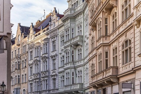 Elegant European facades with ornate architectural details bathed in soft sunlight. The buildings