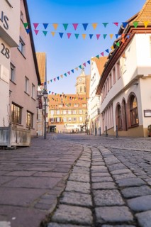 Historic old town street decorated with cobblestones and festive flags, Fasnet, Weil der Stadt,