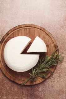 Head of Georgian cheese, Imereti variety, top view, on a cutting board