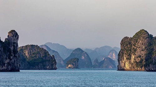 Mighty rocky islands in the soft light of dusk over a calm sea, The landscape and islands of Halong