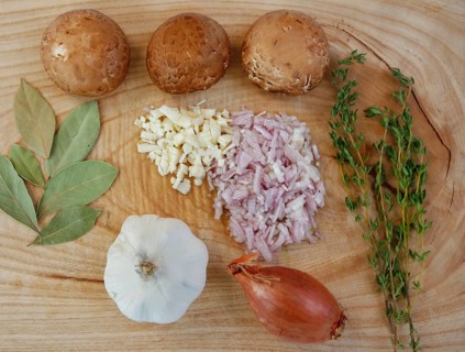 Ingredients on wooden board, preparation, mushrooms, dried bay leaves, onions, garlic cloves,