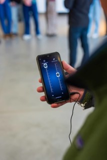 Smartphone in hand, showing an app user interface, modern technology, Porsche Museum, Stuttgart,