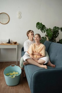 A mother and daughter share a joyful moment while engaging in a self-care routine at home. They are