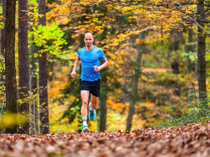 Man in a training session, trail running outdoors, healthy lifestyle, colorful autumn forest,