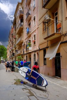 Surfers, SUP paddlers in the old town alleys in the historic fishermen's quarter, Barceloneta