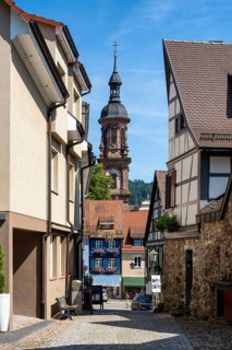 Old town alleyway with half-timbered buildings in Gengenbach with the town church of St Mary,
