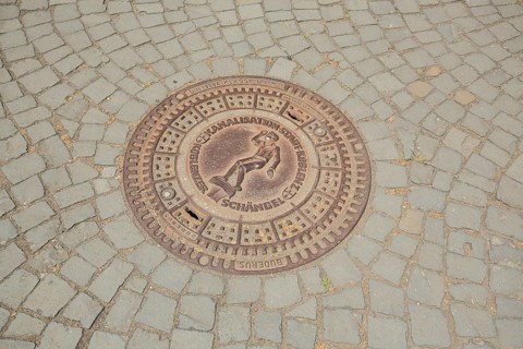Round manhole cover with angel figure, inscription, paving stones, floor, Koblenz,