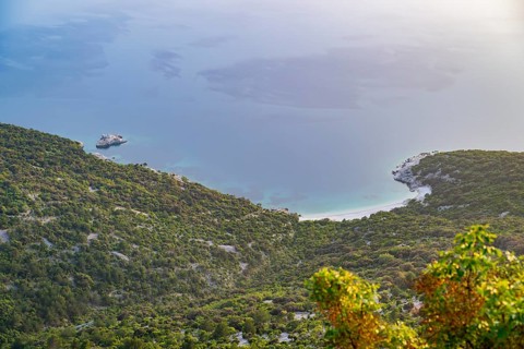 View from Lubenice across the sea with coastal landscape and bays on a sunny day at sunset on the
