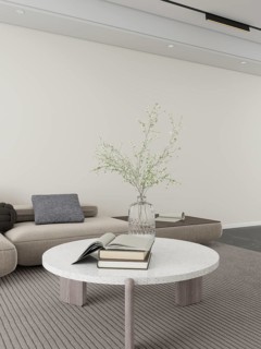 A serene living room featuring a textured sofa, sleek round table, open book, stacked books, and a