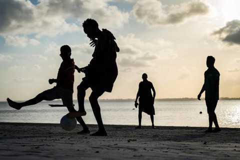 MICHAMVI KAE, ZANZIBAR - OCTOBER 14, 2025: Silhouettes of local men and Maasai playing soccer on a