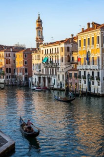 View of the Grand Canal with gondoliers at sunset, picturesque evening mood with palazzos on the