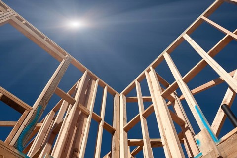 New Construction Framing Abstract with Sunburst Over Clear Blue Sky