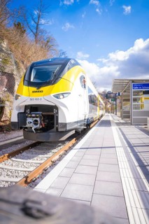 Modern train in yellow and white design on platform under sunny sky, Hermann Hesse Bahn, ZOB, Calw,
