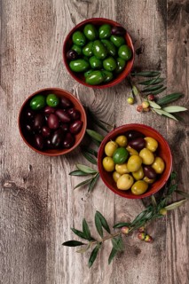 A mixture of olives, varieties of chalkidiki, Verdi giganti and Kalamata, in a bowl, top view, no