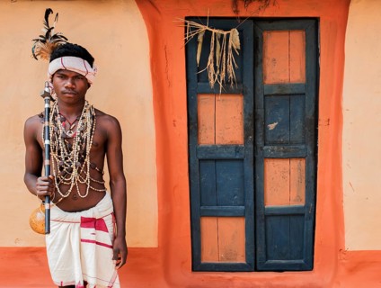 Portrait of a traditionally dressed teenage boy from the Dhurwa tribe (Odisha, India), door of a
