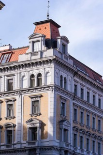 Elegant Prague building showcasing historical architecture with ornate details and red-tiled roofs,